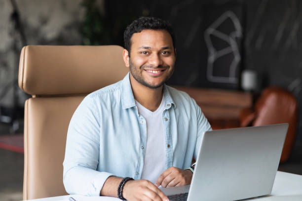 istock Dark-haired indian handsome guy wearing casual shirt using laptop 1333167062