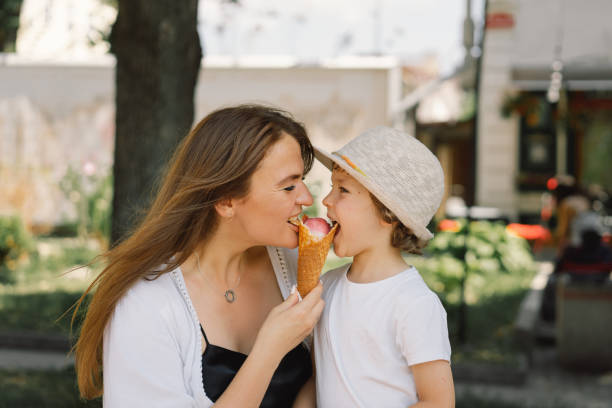 happy mother's day. young mother with small boy outdoors in summer, eating ice cream. people with ice cream. summer food and summer time - nature human pregnancy color image photography imagens e fotografias de stock