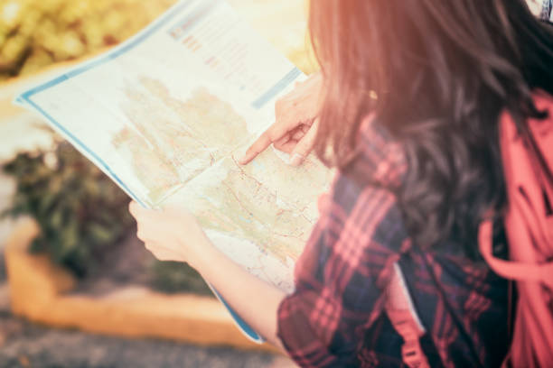 istock Tourists group holding a map and searching direction on location map 1333169119