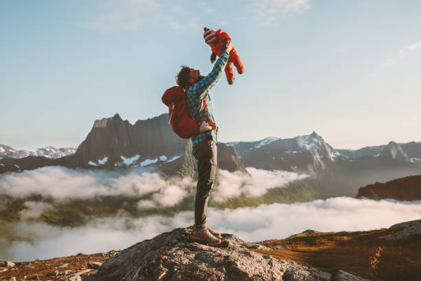 father holding up baby hiking in mountains family fun travel vacation with child active healthy lifestyle man and infant outdoor fathers day holiday - father fathers day baby child imagens e fotografias de stock