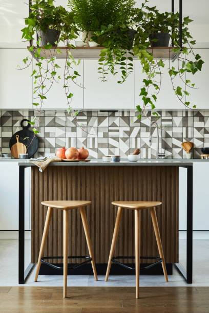 istock Stylish kitchen interior design with dining space. Workspace and kitchen island with kitchen accessories on the back ground. Creative walls with wooden panels. Minimalistic style an plant love concept. 1333170571
