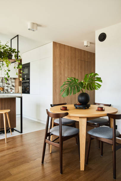 istock Stylish dining space interior design with rounded dining table. Creative walls with wooden panels. Minimalistic style an plant love concept. 1333170638