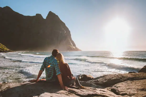 Photo of Couple man and woman in love relaxing on Kvalvika beach travel romantic family vacation outdoor healthy lifestyle in Norway summer holidays trip