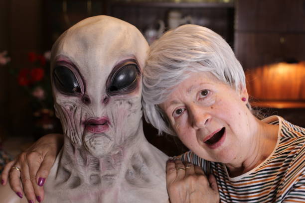 экстатическая похождевая женщина фотографируется с инопланетянином - women spooky old ugliness стоковые фото и изображения
