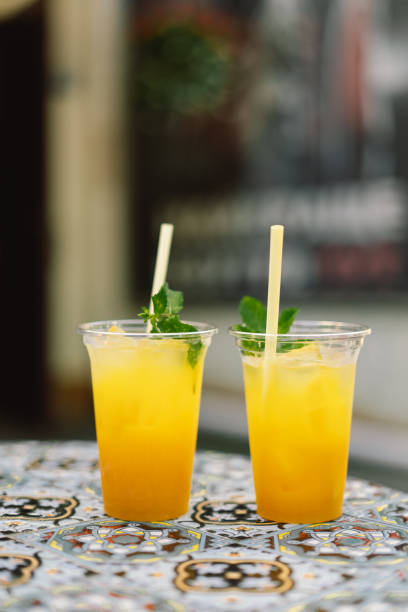 istock Summer yellow Cocktail with ice and mango. Summer day cocktail concept. Cocktail garnished with mint leaf and orange peel 1333177618