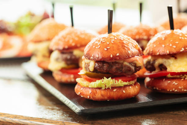 istock Burgers on wooden table in restaurant. 1333177986