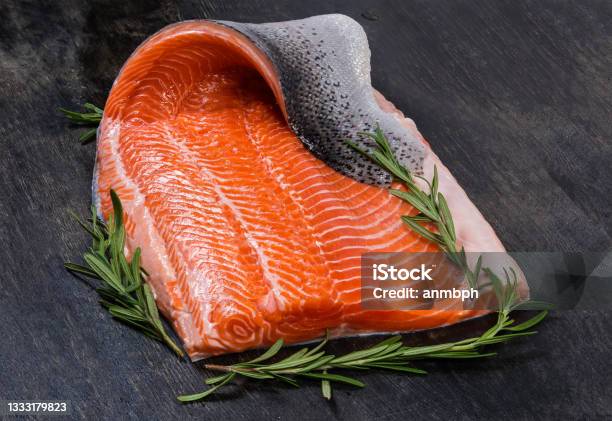 Raw Trout Fillet On Skin With Rosemary On Dark Surface Stock Photo - Download Image Now