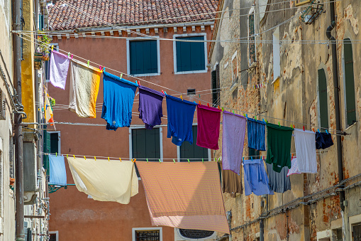 narrow road in Venice with clotheslines between the old venetian houses, Italy