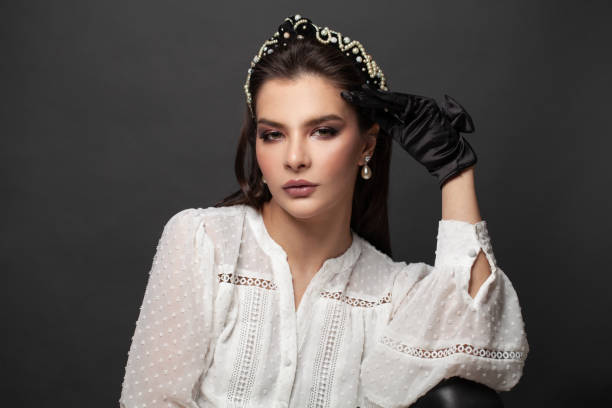 beautiful young woman with headband on her brown hair on black background - earring human face brown hair black hair imagens e fotografias de stock