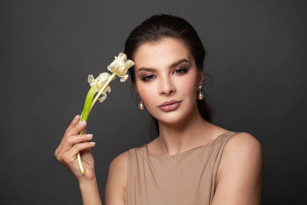 young perfect woman with healthy clean skin and dark brown hair holding dried white flowers on black background - earring human face brown hair black hair imagens e fotografias de stock