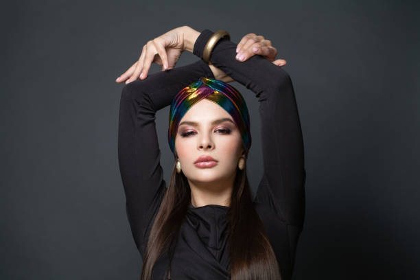 glamorous woman with make up and long brown hair wearing black dress and turban - earring human face brown hair black hair imagens e fotografias de stock