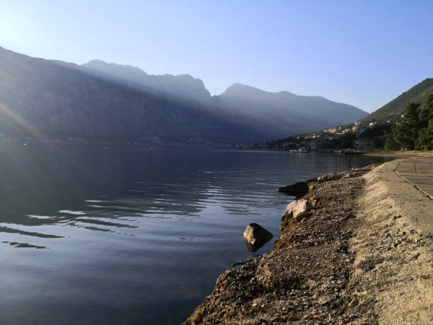 istock Sun rising from behind the mountain, sending sunrays to the seashore. 1333184361