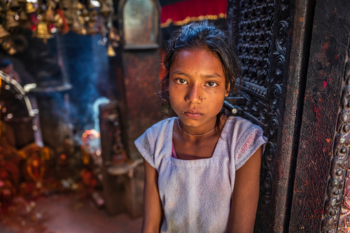 Portrait of young Nepali girl posing in an ancient temple in Bhaktapur. Bhaktapur is an ancient town in the Kathmandu Valley and is listed as a World Heritage Site by UNESCO for its rich culture, temples, and wood, metal and stone artwork.