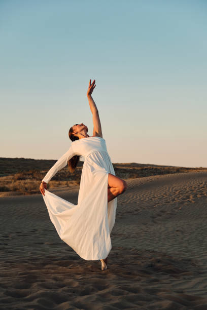 istock Dances in the desert in white dress 1333184693