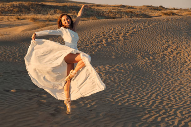 istock Dances in the desert in white dress 1333185742