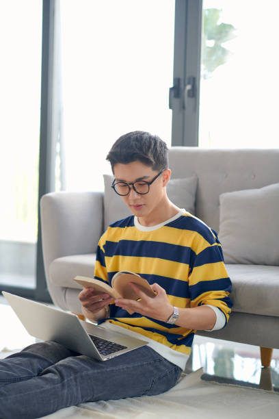 istock Young asian man writing in notebook and using laptop during COVID-19 1333185972