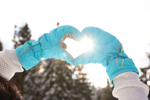 istock Young woman making heart with hands outdoors, closeup. Winter vacation 1333185984