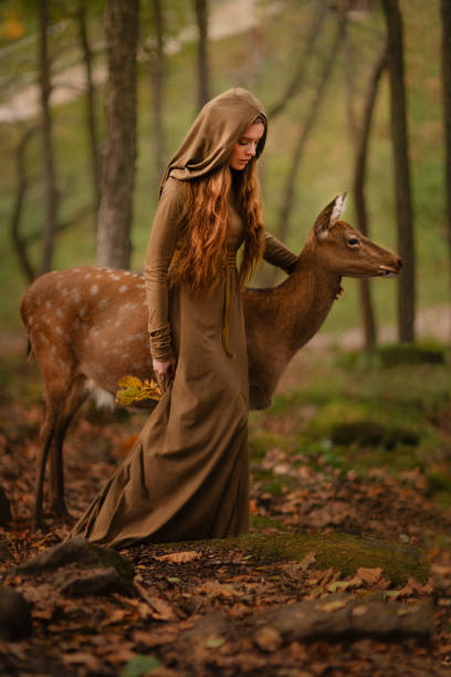 fille rousse avec des cerfs dans une longue robe - fairy forest women magic photos et images de collection