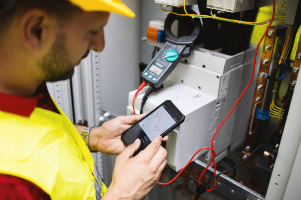 istock Electrician engineer work tester measuring voltage and current of power electric line in electical cabinet control. 1333190469