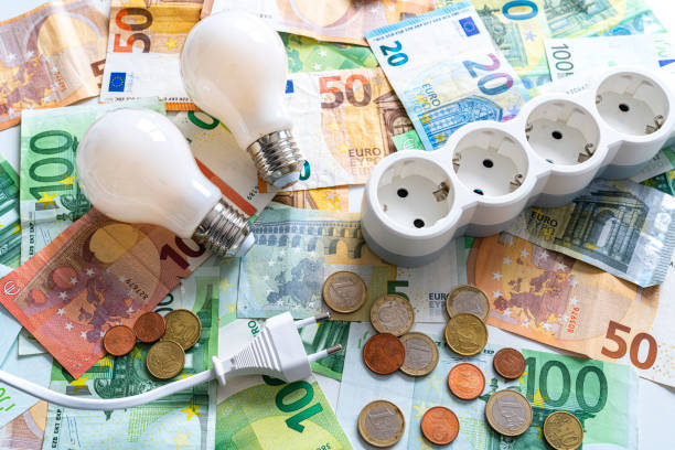 istock Light bulbs and electric plugs on Euro banknotes and coins 1333190532