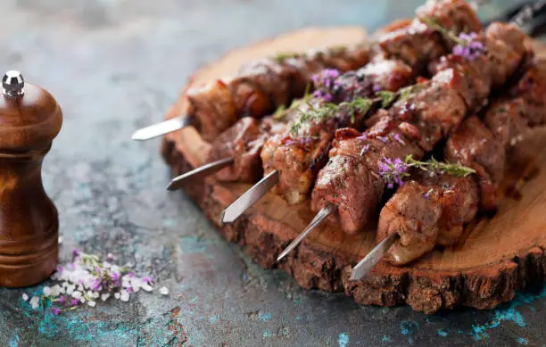 Photo of Shish kebab, Grilled lamb meat skewers with spices and oregano flowers