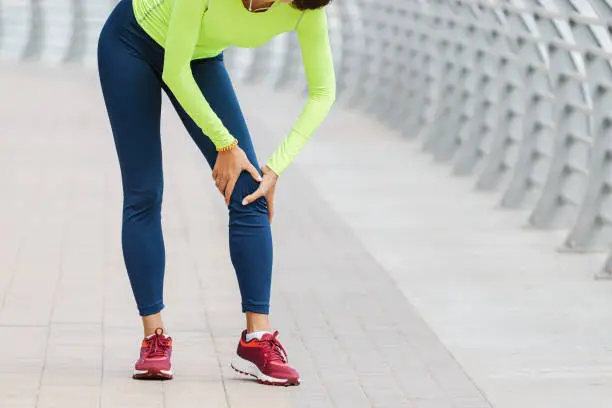 Photo of Young woman was running along the embankment and suddenly felt a sharp pain in the knee joint due to a dislocation or rupture of the meniscus