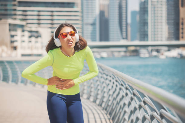 Suffering woman on a jog is experiencing severe pain in her side. Fitness and sports exercises during diseases of the liver, spleen and stomach ulcer Suffering woman on a jog is experiencing severe pain in her side. Fitness and sports exercises during diseases of the liver, spleen and stomach ulcer spleen stock pictures, royalty-free photos & images