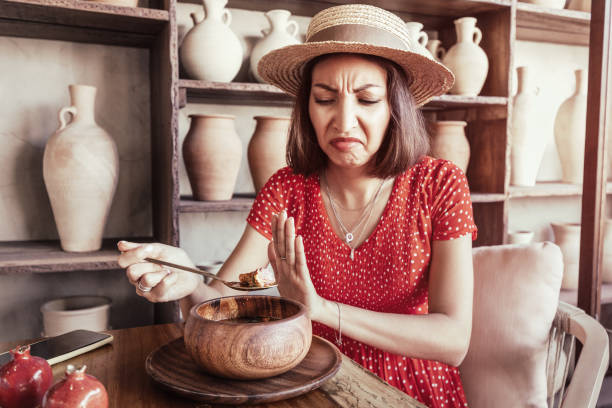 vegetarian woman found a piece of meat in her soup and looks annoyed. vegetarian woman found a piece of meat in her soup and looks annoyed. ugly soup stock pictures, royalty-free photos & images