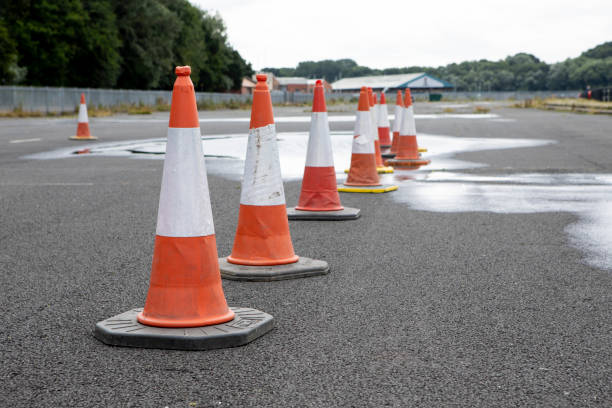 istock Traffic cones in a row in an empty car park with puddles, with copy space 1333198538