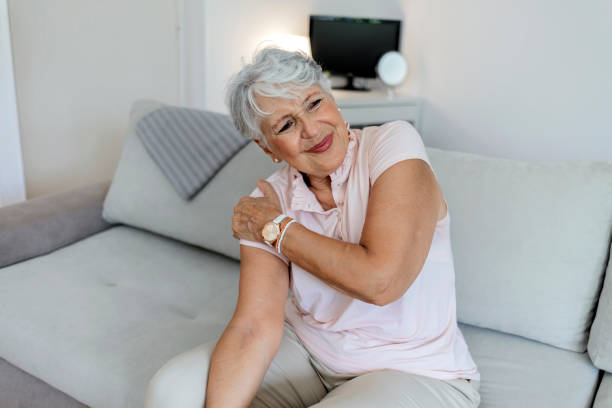 Aging lady is feeling ache in her body. Photo of a aging lady is feeling ache in her body. Senior lady is demonstrating suffering from ache. Elderly woman suffering from pain in shoulder at home. Elderly woman shoulder pain, osteochondrosis shoulder stock pictures, royalty-free photos & images
