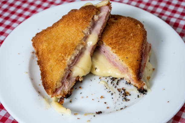 istock Toasted ham and cheese sandwich on a white plate on a table with a tablecloth. 1333198614