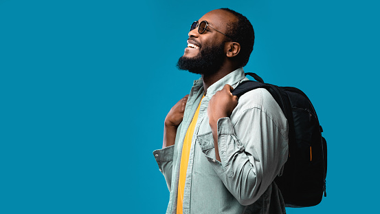 Portrait of happy beard African American tourist with sunglasses in the studio.