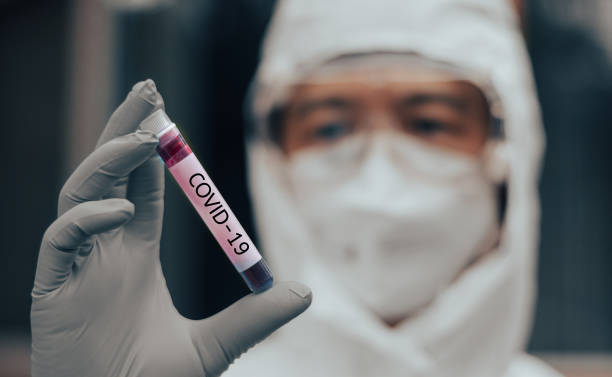 covid-19 назван воз по концепции ncp нового коронавируса. врач или лаборант в костюме сиз, держащий образец крови с новым (новым) коронавирусом в � - коронавирус стоковые фото и изображения