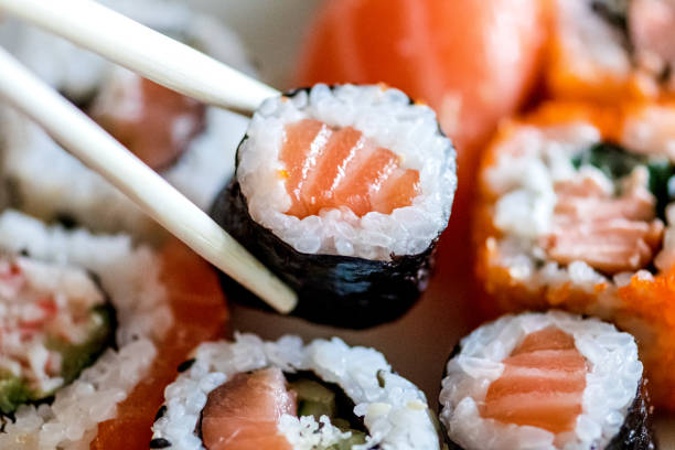 istock Eating various sushi, maki, uramaki, hosomaki e nigiri rolls set in a plate 1333205459