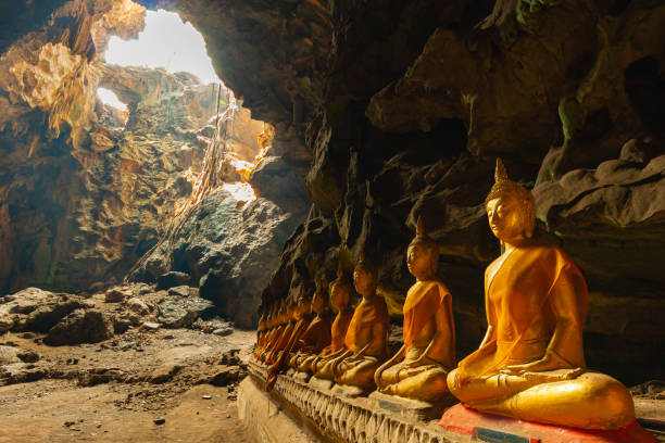 istock beautiful gold buddha sitting underground in natural dark cave 1333205483