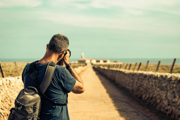 Travel man photographing a lighthouse
