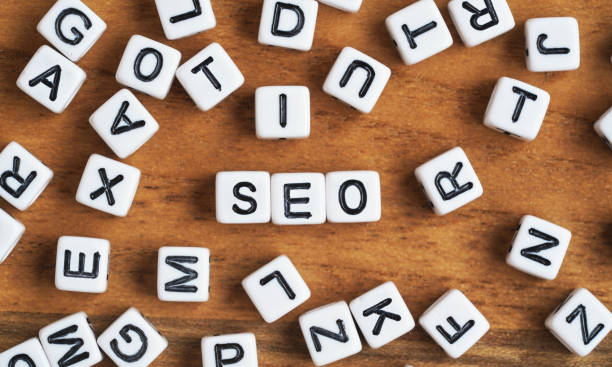 istock Small white and black bead cubes on wooden board, letters in middle spell SEO - Search Engine Optimization concept 1333210185
