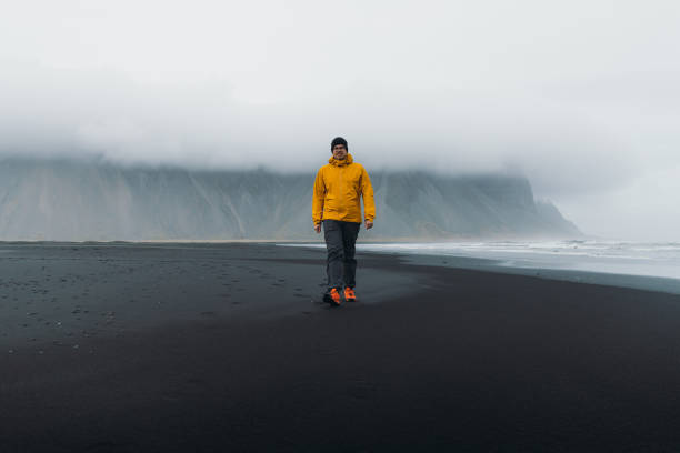 istock Young man traveler exploring the moody black sand beach with mountains view 1333210199
