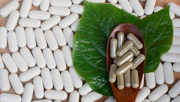 Alternative medicine tablets.Herb capsule,Nutritional dietary supplement,Vitamin Pill,Herbal Medicine on a wooden background with wood spoon. Medical healthcare concept.world antibiotic awareness week