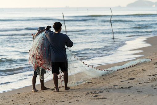 Songkhla, Thailand, May 11, 2020 : The fishermen casting at the Bang Hoi Beach,  in the morning, Songkhla, Thailand.