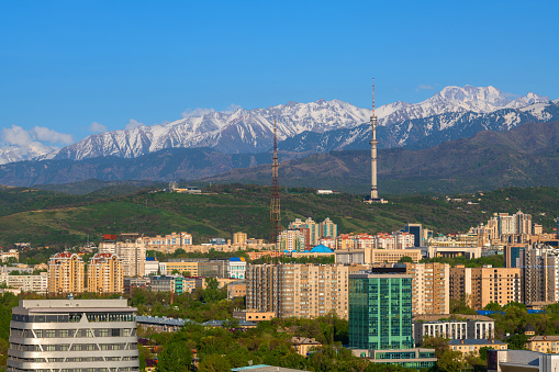 Aerial view of the central part of the city of Almaty against the background of the Zailiyskiy Alatau mountains