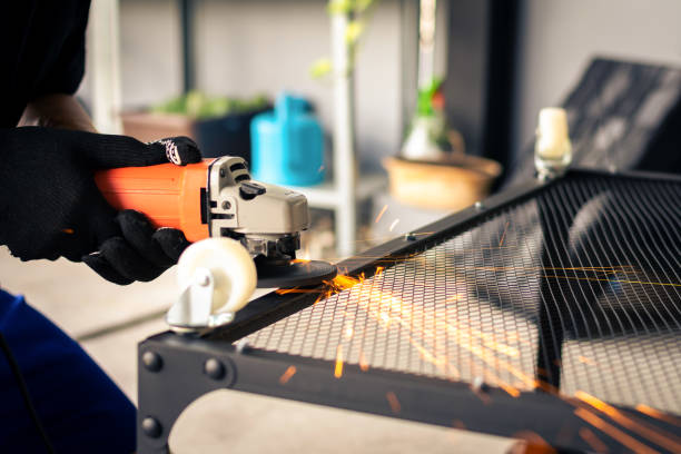 Man using electric grinding on steel table with bright sparks. Man using electric grinding on steel table with bright sparks. steel grinding stock pictures, royalty-free photos & images