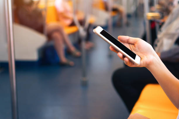 istock Young woman hand holding and using mobile phone inside subway train. Clipping path Display include in this image. 1333213219