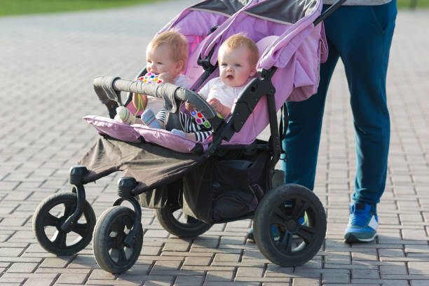 istock Dad on a walk rolls a stroller with his twin daughters 1333214253
