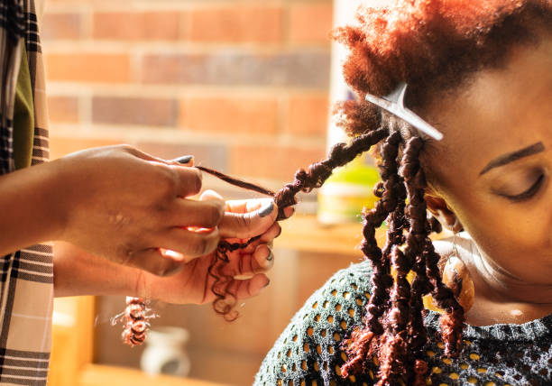 Woman having her hair braided by a stylist in a beauty salon