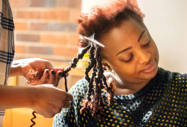Woman getting her hair braided by a stylist in a beauty salon