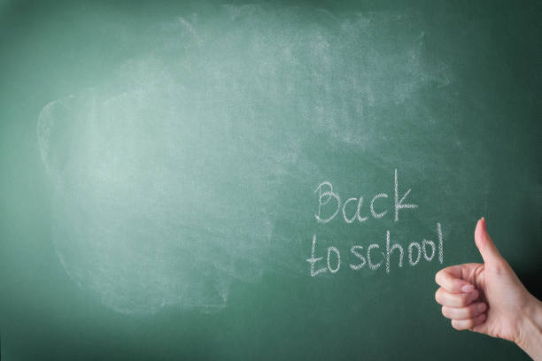 여성 교사들은 학교 게시판에 편지를 쓰고 학교 흰색 분필로 돌아갑니다. 다시 학교에 개념. 디자인을 위해 모의. 공간을 복사합니다. 교육 개념. - reading and writing single word blackboard chalk 뉴스 사진 이미지
