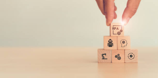 istock RPA Robotic process automation innovation technology concept. Wooden cube with Robot, Operating,  and Artificial intelligence (AI) on light background. Intelligent system automation, banner copy space 1333220747
