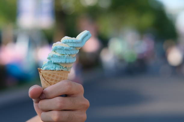 istock hand holding ice cream cone with colorful bokeh 1333220876