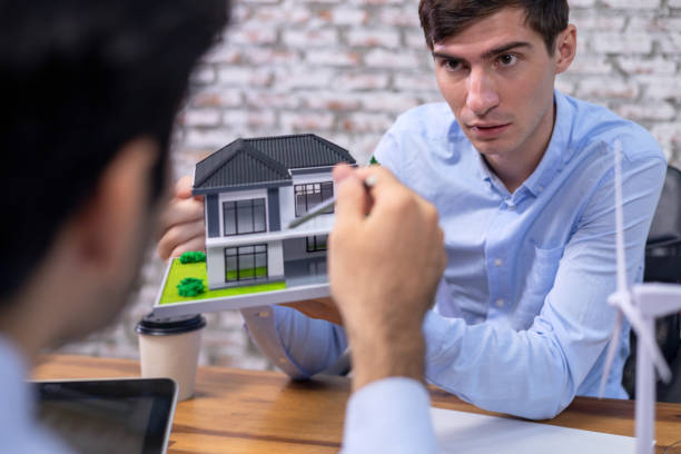 istock Caucasian white engineer and architect are explaining or exchange ideas about renewable energy solution for housing development project in office. 1333222896